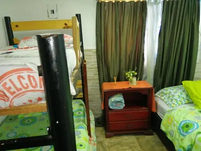 a bedroom with two bunk beds and a table with a drawer at Villa mar in Puerto Colombia