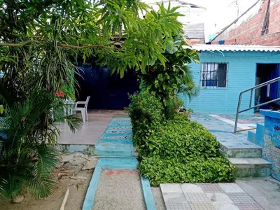a courtyard with a blue house with a tree at Villa mar in Puerto Colombia
