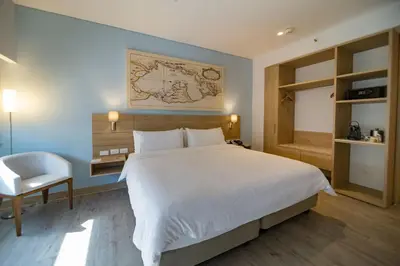 a bedroom with a large white bed and a chair at Holiday Inn Express Cartagena Manga by IHG in Cartagena de Indias