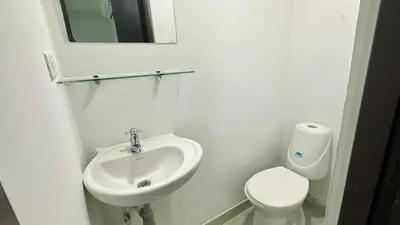 a white bathroom with a sink and a toilet at Hotel Casa Paraiso in Barranquilla