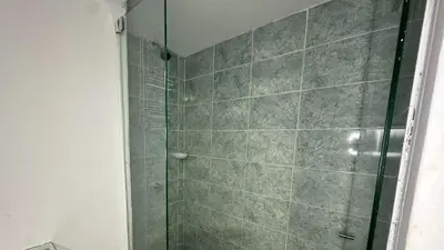 a shower with a glass door in a bathroom at Hotel Casa Paraiso in Barranquilla