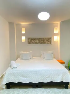 a bedroom with a large bed with white sheets at Patio de Getsemani in Cartagena de Indias