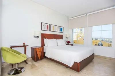 a hotel room with a bed and a chair at NH Royal Urban Cartagena in Cartagena de Indias