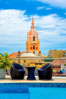 a building with a clock tower in front of a swimming pool at NH Royal Urban Cartagena in Cartagena de Indias