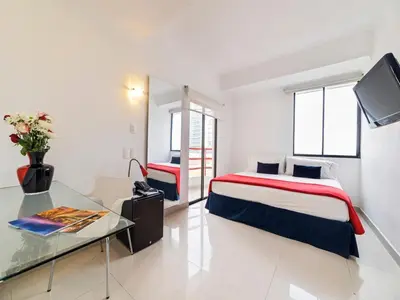 a hotel room with a bed and a glass table at Zalmedina Hotel in Cartagena de Indias