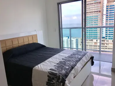 a bedroom with a bed and a large window at luxuriuso apartament in Cartagena de Indias