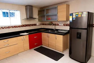a kitchen with a stainless steel refrigerator and red cabinets at Departamento Bocagrande cerca a playas in Cartagena de Indias
