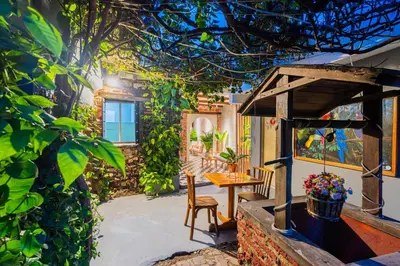 a patio with a table and chairs and a tree at Casa Del Pozo Boutique - Full House in Cartagena de Indias