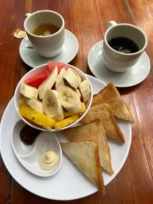 a plate with a bowl of toast and a cup of coffee at Santuario Getsemani Hostel in Cartagena de Indias