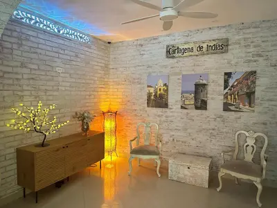 a room with two chairs and a dresser and a brick wall at Hotel La Magdalena in Cartagena de Indias
