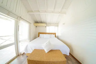 a bedroom with a bed with a bench in it at Quinta del Mar Sunset in Isla Mucura