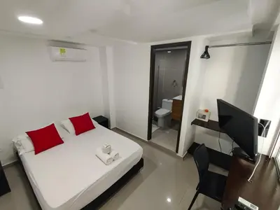 a bedroom with a bed and a desk and a television at Hotel Or Cartagena in Cartagena de Indias