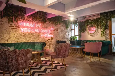 a restaurant with green furniture and a wall with a neon sign at Hotel Casa La Factoria by Faranda Boutique, a member of Radisson Individuals in Cartagena de Indias
