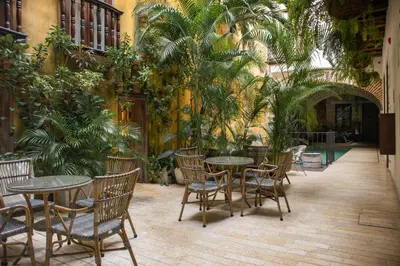 a courtyard with tables and chairs and plants at Hotel Casa La Factoria by Faranda Boutique, a member of Radisson Individuals in Cartagena de Indias