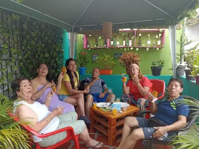 a group of people sitting on a porch eating food at Hostel Shalom Adonai in Cartagena de Indias