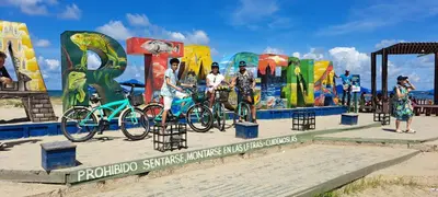 a group of people standing next to bikes on a beach at Hostel Shalom Adonai in Cartagena de Indias