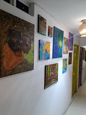 a wall full of paintings on a wall at Hostel Shalom Adonai in Cartagena de Indias