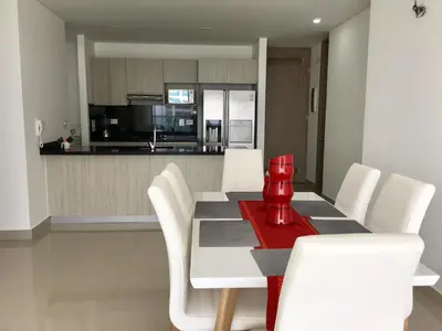a dining room with a table and white chairs at Luxury Infinitum in Cartagena de Indias