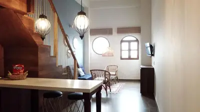 a living room with a table and chairs and a staircase at Soy Local Centro Histórico in Cartagena de Indias