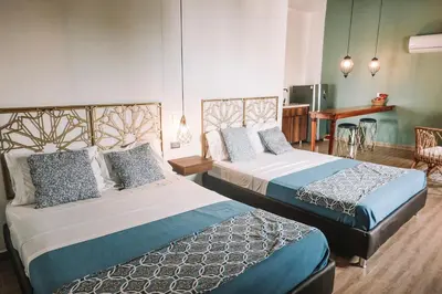 a hotel room with two beds and a table at Soy Local Centro Histórico in Cartagena de Indias