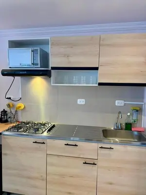 a kitchen with a stove top and wooden cabinets at Palmera Beach in Cartagena de Indias