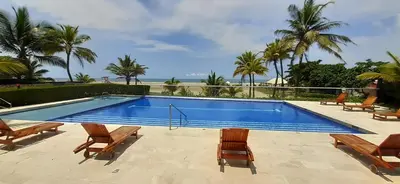 a swimming pool with chairs and the ocean in the background at Morros Vitri Cartagena in Cartagena de Indias