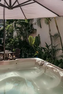 a bath tub in a garden with an umbrella at Mucura Hotel & Spa in Cartagena de Indias