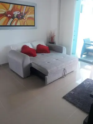 a couch with two red pillows in a living room at Apartamento seaway 935 Morros, La Boquilla in Cartagena de Indias