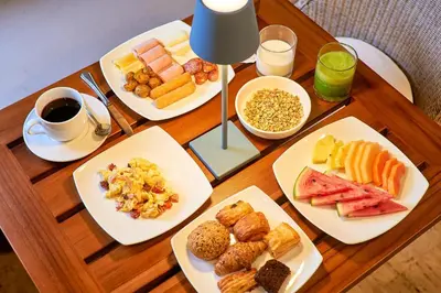 a wooden table topped with plates of breakfast foods at Hotel San Pedro de Majagua in Isla Grande