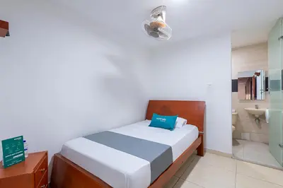 a bedroom with a bed and a bathroom at Hotel Nuevo Yalu in Barranquilla
