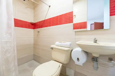 a bathroom with a toilet and a sink at Hotel Nuevo Yalu in Barranquilla