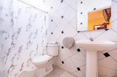 a bathroom with a toilet and a sink at Hotel Nuevo Yalu in Barranquilla