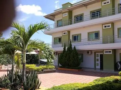 a large building with palm trees in front of it at Terra Toscana Hotel in Mangue