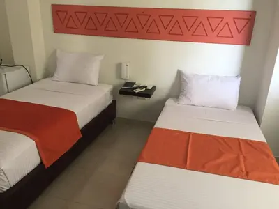 two beds in a hotel room with a red headboard at Terra Toscana Hotel in Mangue