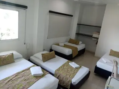 a room with three beds in a room with a window at Terra Toscana Hotel in Mangue