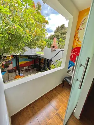 a view from the hallway of a house with a large window at Hostal Casa Tropicalia in Barranquilla