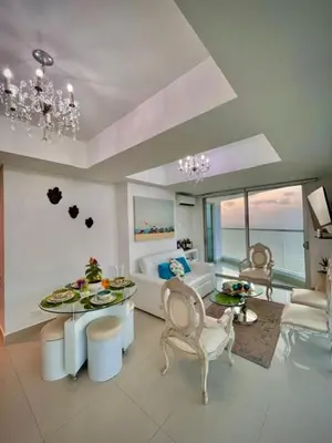 a living room with a table and chairs and a couch at Beach front Apartament in Cartagena de Indias