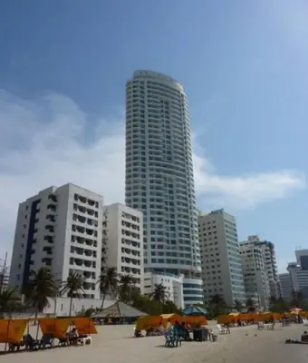 a beach with umbrellas in front of tall buildings at Beach front Apartament in Cartagena de Indias