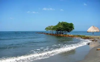 an island in the ocean with trees and an umbrella at Cabaña Coveñas Punta Bolivar in Coveñas