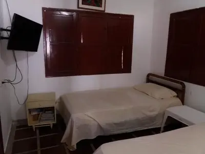 a small bedroom with two beds and a window at Cabaña Coveñas Punta Bolivar in Coveñas