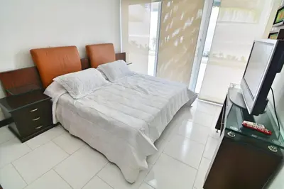 a bedroom with a bed and a flat screen tv at Cartagena vista directa al mar amplio apt con terraza privada in Cartagena de Indias