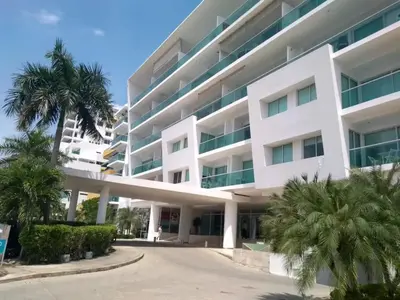 a large white building with palm trees in front of it at Cartagena vista directa al mar amplio apt con terraza privada in Cartagena de Indias