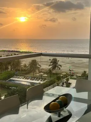 a table with a bowl of fruit on a balcony with the beach at morros 3 in Cartagena de Indias