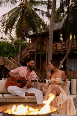 a man and a woman sitting on a couch with a guitar at Hotel Isla del Encanto in Baru