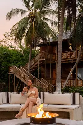 a man sitting on a couch in front of a building at Hotel Isla del Encanto in Baru