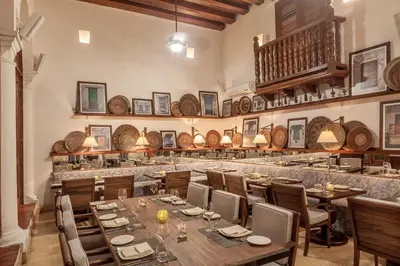 a restaurant with wooden tables and chairs and a bar at Hotel Casa San Agustin in Cartagena de Indias