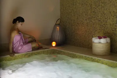 a woman sitting in a bath tub with a candle at Hotel Casa San Agustin in Cartagena de Indias