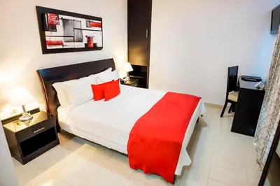 a bedroom with a large bed with a red blanket at Hotel Atlantic Lux in Cartagena de Indias