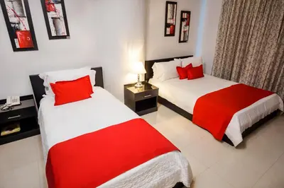 two beds in a room with red and white at Hotel Atlantic Lux in Cartagena de Indias