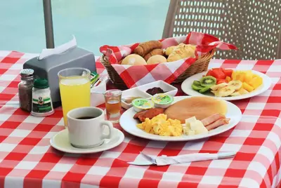 a table with plates of food and a basket of food at Hotel Atlantic Lux in Cartagena de Indias